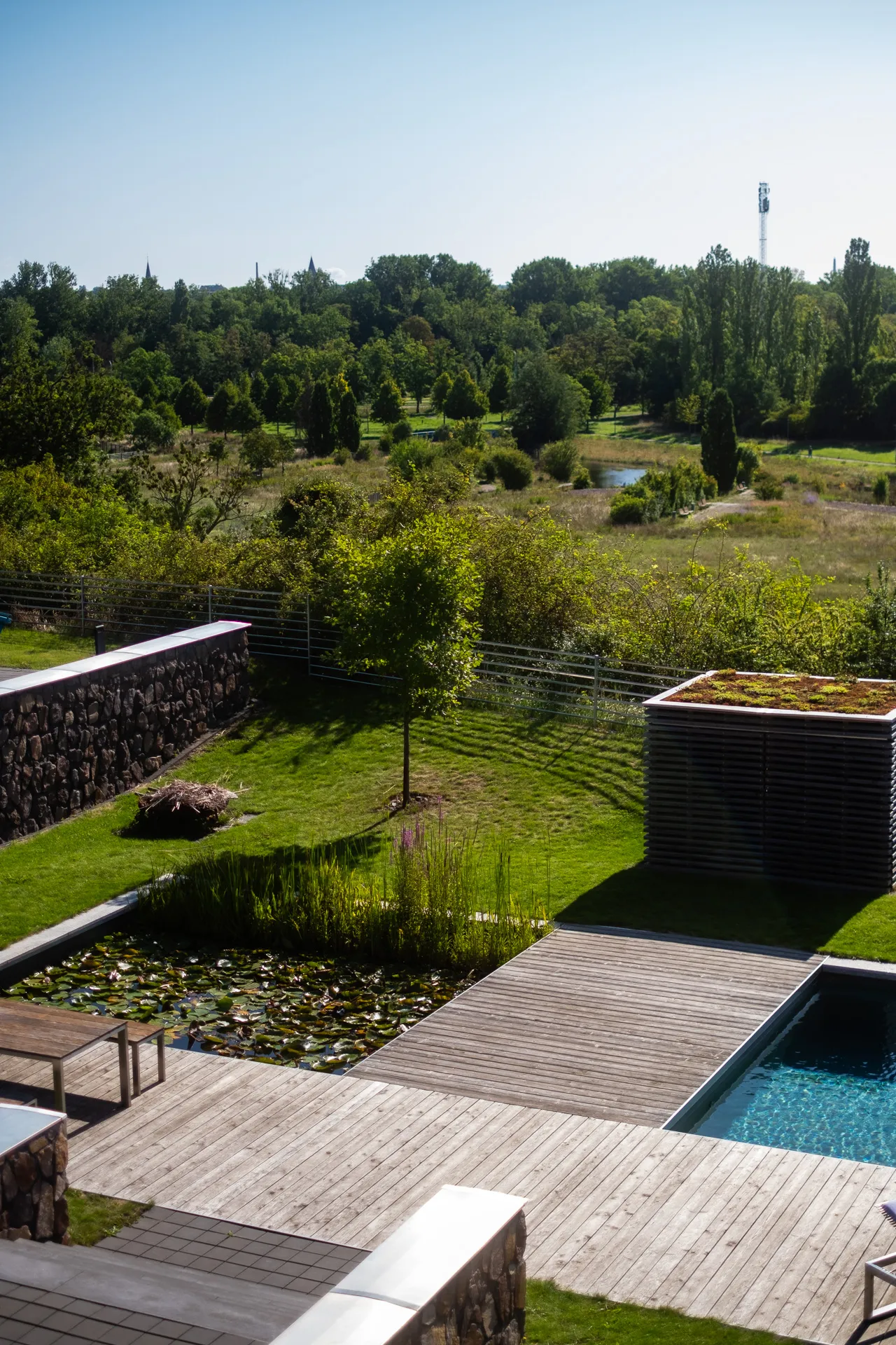 Blick von der Außenanlage auf Grünflächen und Wasserbereich am Gelände