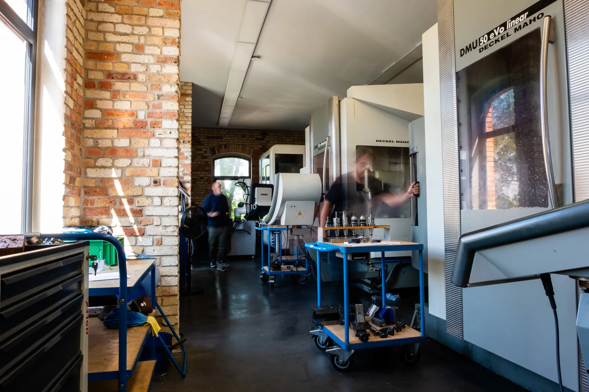 CNC-Fertigungshalle mit Bearbeitungszentren, Werkzeugwagen und Arbeitsplätzen