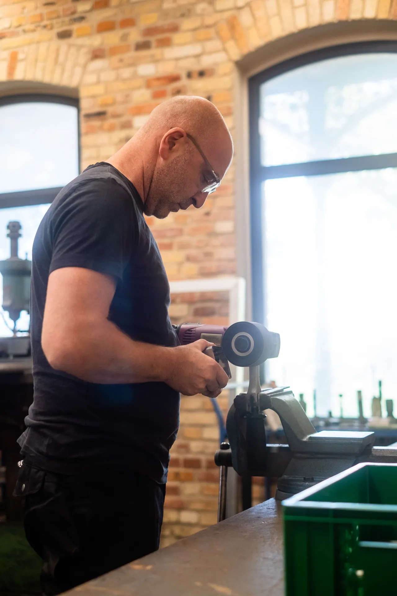 Manuelle Nacharbeit am Werkstück am Schraubstock mit Handmaschine