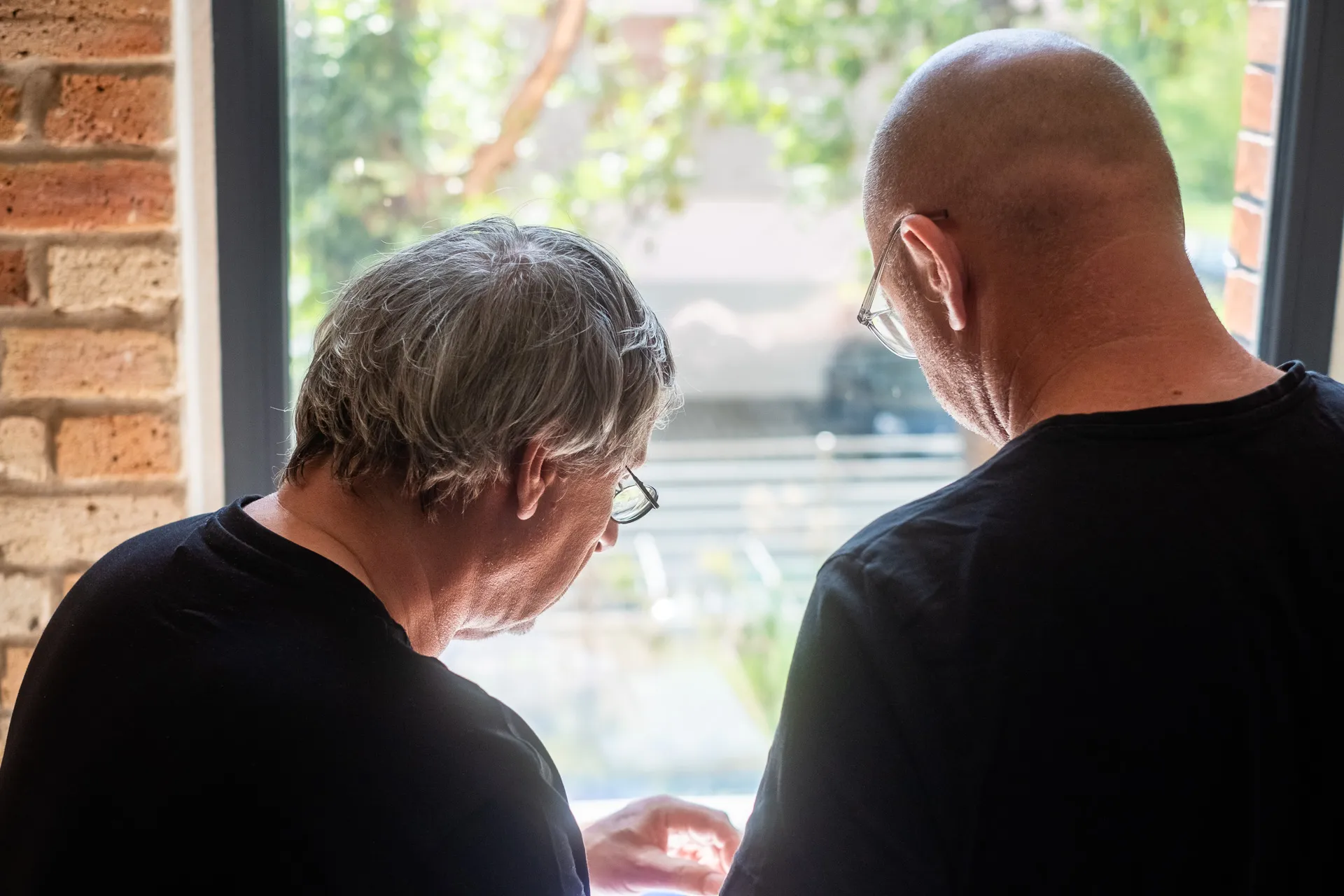 Zwei Mitarbeiter stimmen Fertigungsschritte anhand eines Werkstücks ab