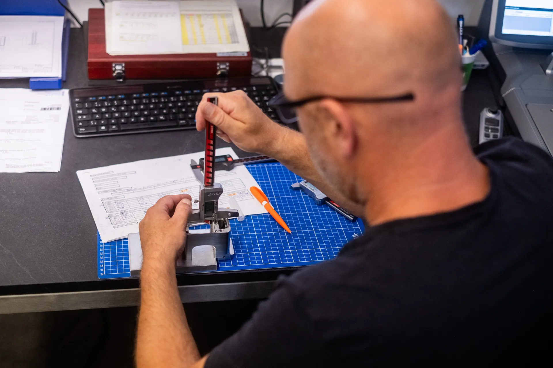 Höhenmessung eines Bauteils mit Messgerät am Arbeitsplatz der Qualitätssicherung